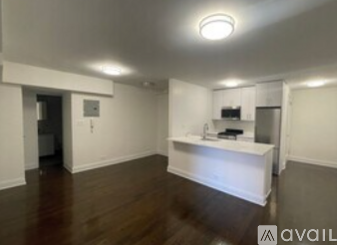 A room with a kitchenette and a refrigerator.