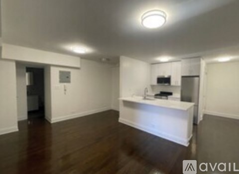 A room with a kitchenette and a refrigerator.