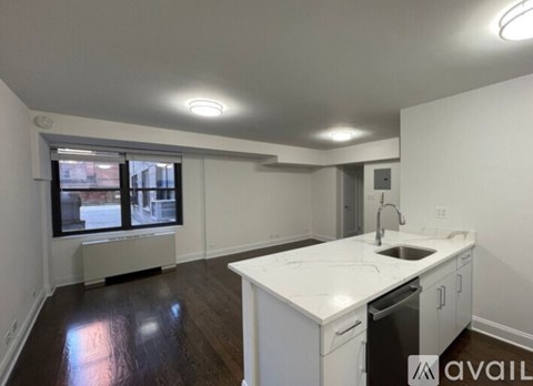 A kitchen with white countertops and a dishwasher is available for rent.