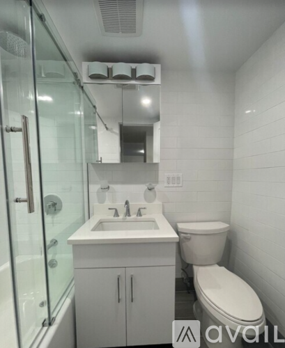 A white bathroom with a toilet, sink, and mirror.