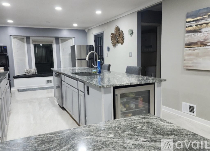 A kitchen with granite countertops and a fridge with a picture of a beach on the wall.