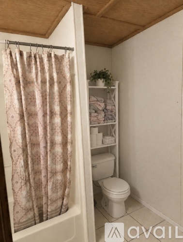A small bathroom with a toilet and a shelf.