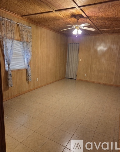 A room with wooden walls and a ceiling fan.