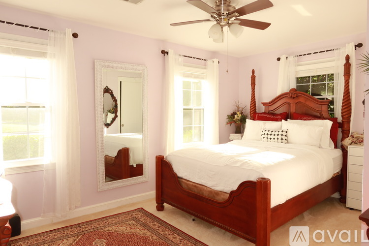 A bedroom with a large bed and a mirror on the wall.