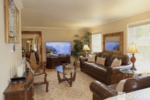 A living room with a brown leather couch and a coffee table.