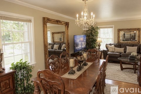A dining room with a wooden table and chairs.