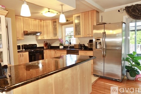 A kitchen with wooden cabinets and a black countertop.