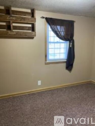 A room with a window and a curtain.