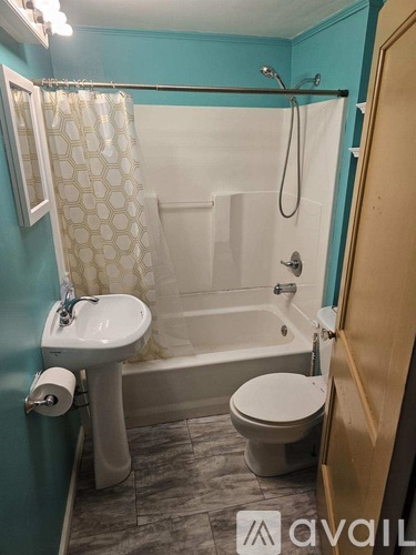 A small bathroom with a toilet, sink, and bathtub.