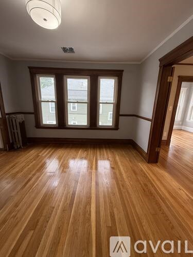 A room with wooden flooring and a window.