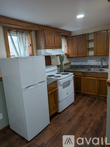 A kitchen with a white fridge and wooden cabinets.