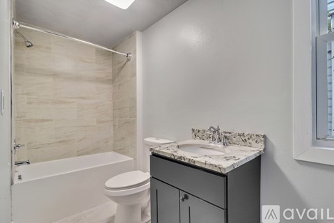 A bathroom with a white toilet, a sink, and a bathtub.