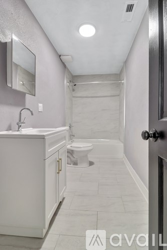 A bathroom with a toilet, sink, and mirror.