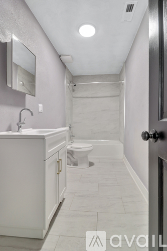A bathroom with a toilet, sink, and mirror.