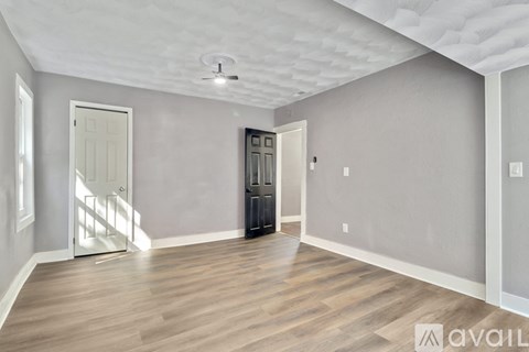 A room with wooden flooring and a ceiling fan.