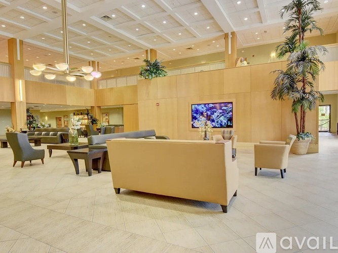 A spacious waiting area with a large couch, chairs, and a television.