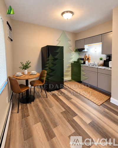 A kitchen with a table and chairs in the foreground and a refrigerator with a tree design on it in the background.