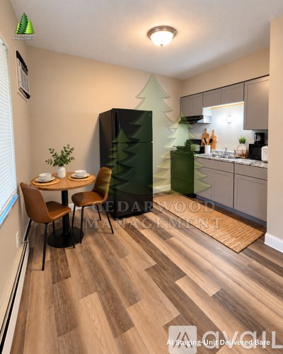 A kitchen with a table and chairs in the foreground and a refrigerator with a tree design on it in the background.