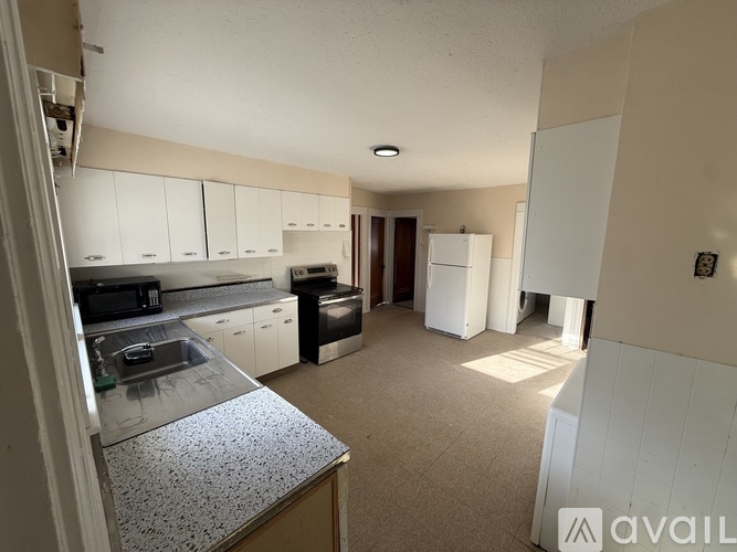 A kitchen with a stainless steel sink and a refrigerator.
