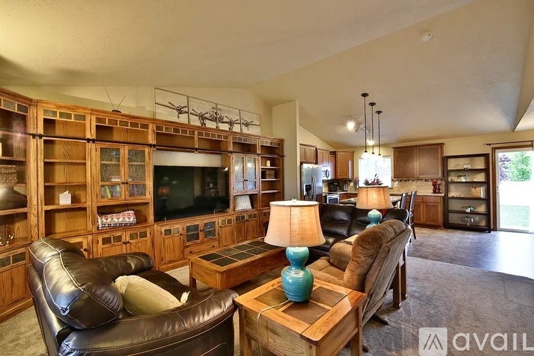 A living room with a leather couch, a wooden coffee table, and a television.