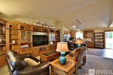 A living room with a leather couch, a wooden coffee table, and a television.
