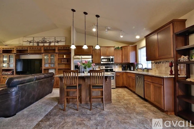 A kitchen with wooden cabinets and a black sofa.