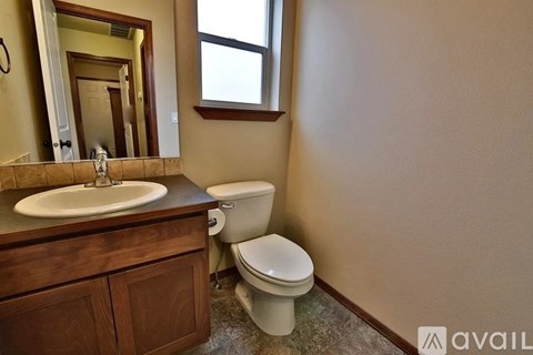 A bathroom with a toilet, sink, and mirror.