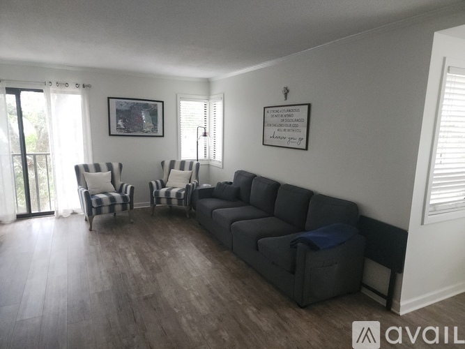 A living room with a grey sofa and striped armchairs.