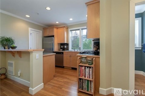 A kitchen with wooden cabinets and a bookshelf filled with books.