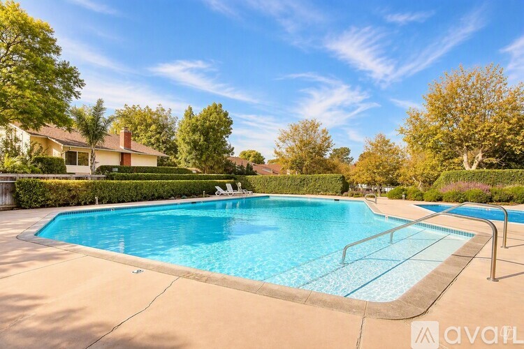 A swimming pool surrounded by a concrete floor and a metal railing.