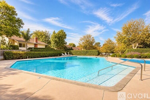 A swimming pool surrounded by a concrete floor and a metal railing.
