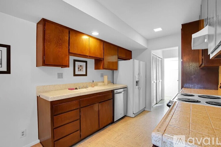 A kitchen with wooden cabinets and a white countertop.