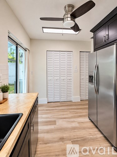 A kitchen with a stainless steel refrigerator and wooden countertops.