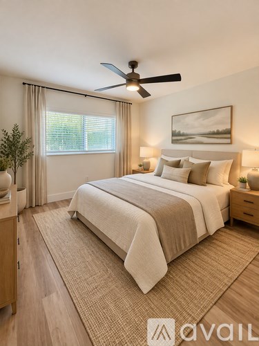 A bedroom with a large bed and a ceiling fan.