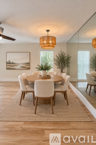 A dining room with a round table and chairs.