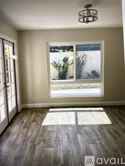 A room with a large window and wooden flooring.