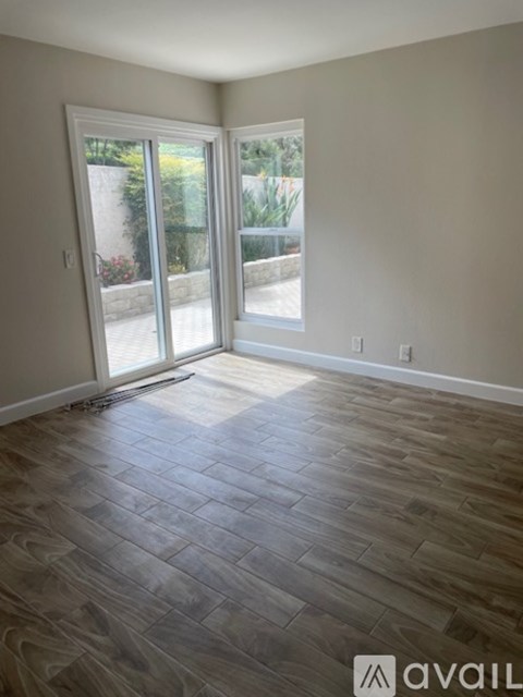 A room with a wooden floor and a sliding glass door.