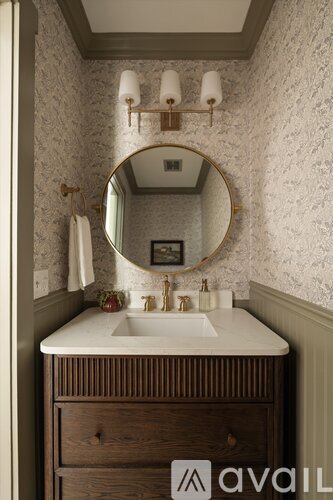 A bathroom with a sink, mirror, and light fixture.