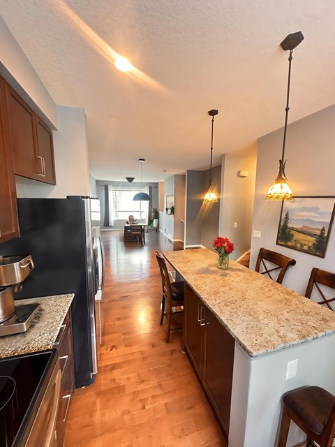 A kitchen with a granite counter top and wooden cabinets.