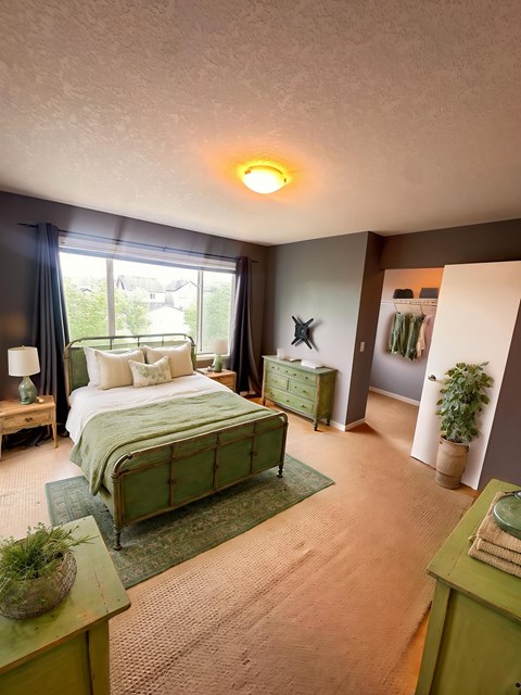 A bedroom with a green bed and a green nightstand.