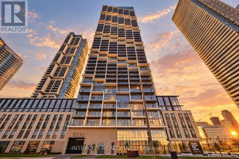 A tall building with the number 1000 on it is in the foreground of a sunset.