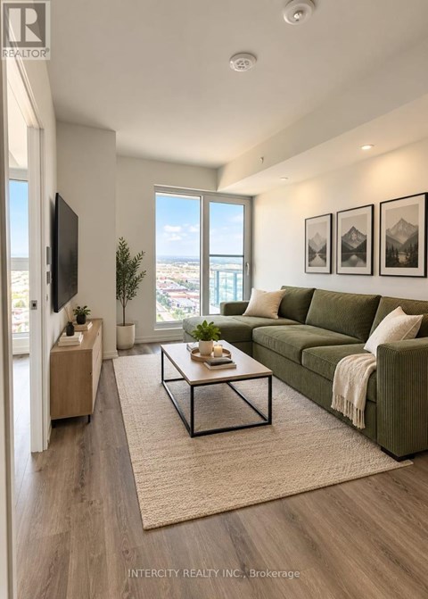A living room with a green couch and a flat screen TV mounted on the wall.