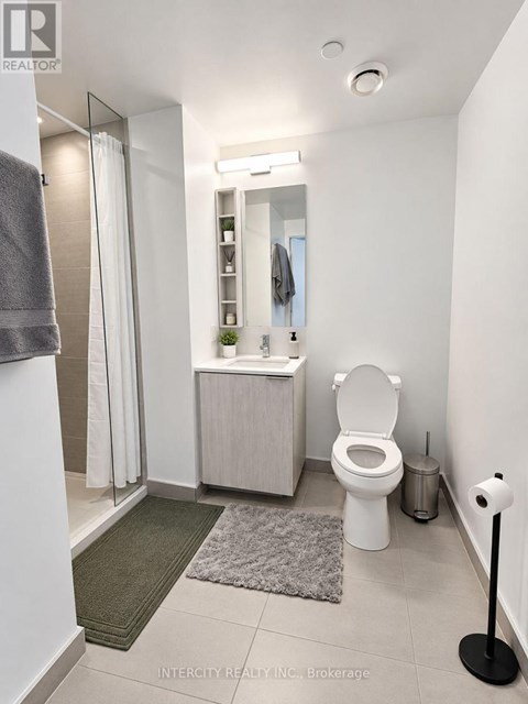A white bathroom with a toilet, sink, and mirror.