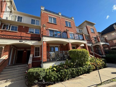 A red brick building with a balcony and a bicycle parked in front.