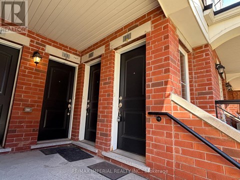 A red brick house with two black doors and a small porch.