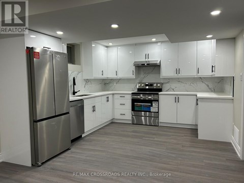A modern kitchen with a stainless steel refrigerator and white cabinets.