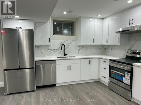 A modern kitchen with a stainless steel refrigerator and white cabinets.