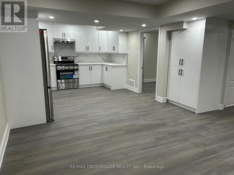 A kitchen with white cabinets and a wooden floor.