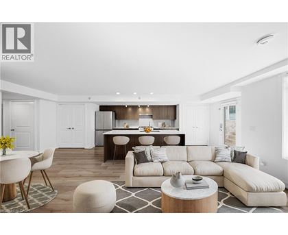 A modern living room with a large white sofa and a dining area in the background.