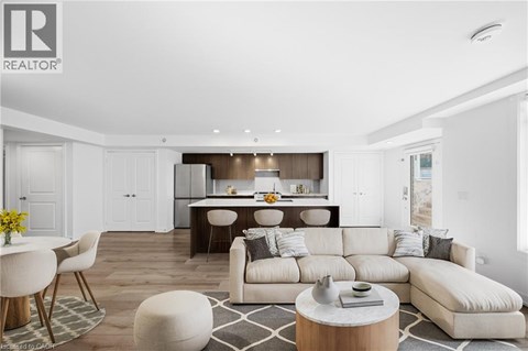 A modern living room with a large white sofa and a dining area in the background.
